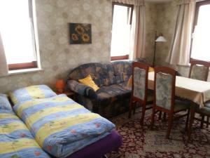 ein Wohnzimmer mit einem Sofa, einem Tisch und Stühlen in der Unterkunft Haus Schammes in Wutha-Farnroda
