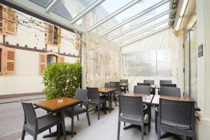 eine Terrasse mit Tischen und Stühlen in einem Restaurant in der Unterkunft Calvy in Genf