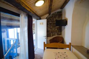 a room with a table and a chair and a television at Traditional Piran house in Piran