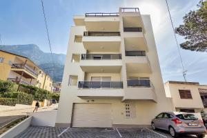 un edificio con un'auto parcheggiata di fronte di Apartment Đaninovica I a Makarska