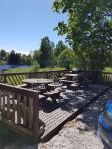 a group of picnic tables on a wooden deck at meijeriranta majoitus in Ylistaro