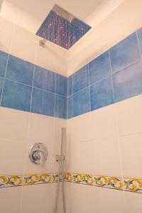 Un baño con ducha con azulejos azules y blancos. en Zaffiro, en Maiori 45 fotos más
