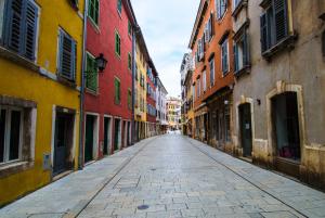 an empty street in a city with colorful buildings at DeLuxe Afrodita Apartment in Rovinj