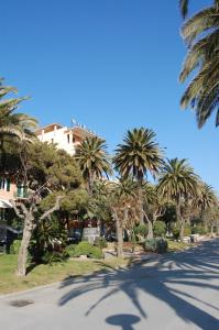 a street with palm trees in front of a building at Grand Hotel Moroni in Finale Ligure