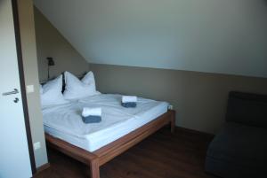Bett mit weißer Bettwäsche und Kissen in einem Zimmer in der Unterkunft Ferienwohnung Sommeregger in Leutschach