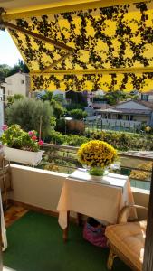 un tavolo con un vaso di fiori sul balcone di Chambre chez l’habitant chez Nadine a Cagnes-sur-Mer