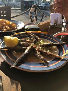 a plate of sausages and a lemon on a table at La Manga Apartment Capri in La Manga del Mar Menor