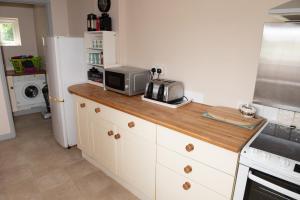 a kitchen with a counter with a toaster and a microwave at The Studio in Somerton