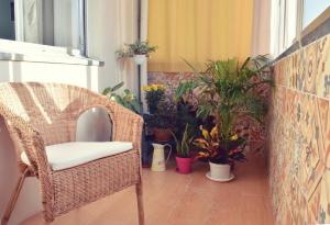 a wicker chair sitting on a balcony with plants at A Casa da Maria in Porto