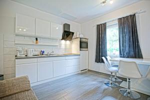 a kitchen with white cabinets and a table and chairs at Stettiner Haff Nebengebäude in Mönkebude