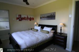 um quarto com uma cama com duas almofadas em Birdsong Cottages em Champagne Valley