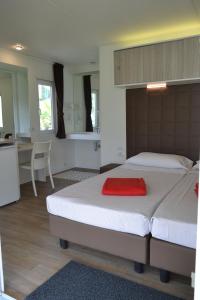 1 dormitorio con 2 camas y cocina con mesa en Camping Spiaggia D' Oro Torri, en Torri del Benaco