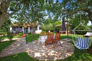 a patio with two chairs and a table and a swing at Holiday Home Sergo in Poreč