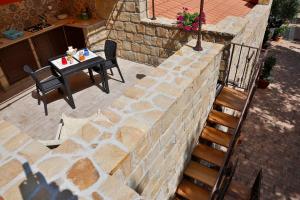 a stone wall with a table and a table and chairs at Campeggio Sanfilippo in Cefalù