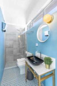 a bathroom with a sink and a toilet and a mirror at Downtown Boutique Apartments Acropolis View in Athens