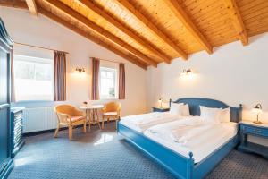 Schlafzimmer mit einem blauen Bett und einem Tisch in der Unterkunft Hotel Garni Getreuer Eckart in Binz