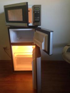 a microwave on a stand with an open refrigerator at Walk to Indian Rocks Beach Exclusive Use of Hot Tub, Pool, BBQ,with Privacy in Largo
