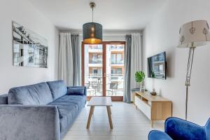 a living room with a blue couch and a table at NORDBYHUS Apartamenty Chmielna Park in Gdańsk
