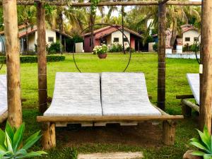 a wooden bench in a park with a swing at Mar Doce Boutique Hotel in Três Marias