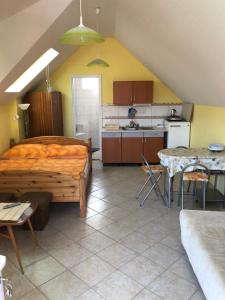 a bedroom with a bed and a kitchen with a table at Liget apartman in Balatonföldvár