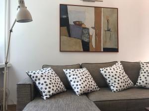 een woonkamer met een bank met kussens en een schilderij bij Nina na Bielańskiej in Warschau