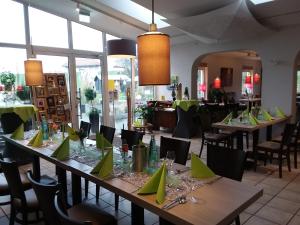 BachenbrockにあるDat Sandmann Huusのダイニングルーム(テーブル、椅子、緑のナプキン付)