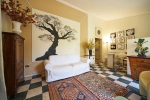 una sala de estar con un sofá blanco y un árbol en la pared en Cottage del Limone en Spoleto