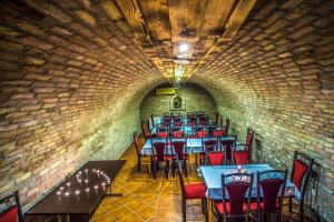 a dining room with tables and chairs in a brick wall at Patak Park Hotel Visegrád in Visegrád