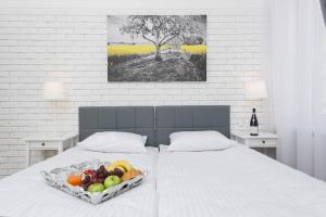 a tray of fruit on a bed in a bedroom at Salomea Krakow apartments in Krakow