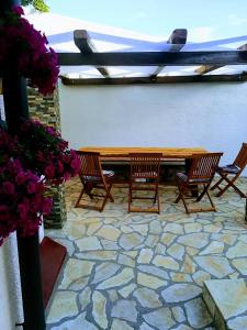 une terrasse en pierre avec une table en bois et quatre chaises dans l'établissement Solovi Dvori, à Karlobag