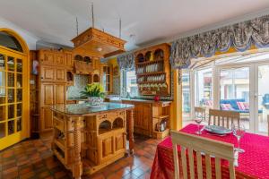 韋克斯福德的住宿－Ballysheen House，厨房配有木制橱柜和一张红色桌子。