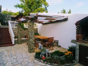 eine Terrasse mit einem Holztisch und einem Holzschirm in der Unterkunft Solovi Dvori in Karlobag