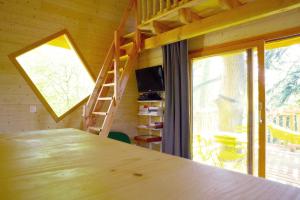 a large wooden table in a room with a window at Le Monde de Charlie - Les Cabanes in Bellerive-sur-Allier