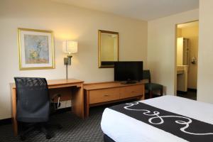 a hotel room with a desk and a bed and a computer at La Quinta by Wyndham Tampa Fairgrounds - Casino in Tampa