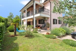 een huis met een balkon en een tuin bij Apartments Radović in Labin