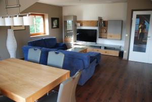 ein Wohnzimmer mit einem blauen Sofa und einem Tisch in der Unterkunft Ferienwohnung Sommeregger in Leutschach