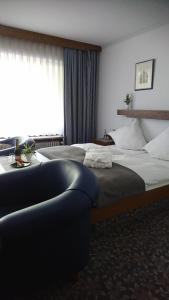 a hotel room with two beds and a couch at Café Blaich - Hotel Garni in Höfen an der Enz