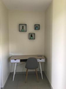 een bureau met een stoel en twee foto's aan de muur bij Appartement dans Résidence les Dunes du Golf in Wimereux