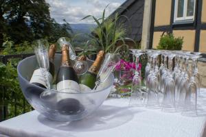 um balde de champanhe e taças de vinho numa mesa em Gasthaus und Ferienwohnungen "Zum Büchsenmacher" em Wernigerode
