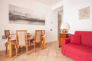 a living room with a red couch and a table and chairs at Residenza "Il Torrazzo" in Cremona