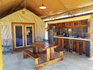 a kitchen with a wooden table in a tent at OuKlip Game Lodge in Klipdrift