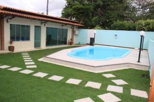 a swimming pool in a yard next to a house at Jacarandá Palace Hotel in Teixeira de Freitas