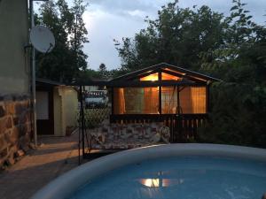 a house with a pool in front of a building at Páros faház in Balatonföldvár