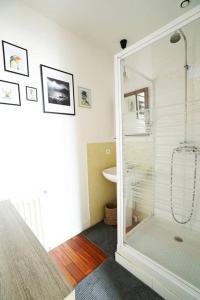 uma casa de banho com um chuveiro e uma porta de vidro em Au Petit Bonheur em Talence