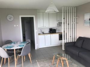 ヴィムルーにあるAppartement dans Résidence les Dunes du Golfのリビングルーム(ソファ、テーブル、椅子付)