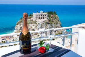 una botella de champán y dos copas de vino en una mesa en Sunset Tropea, en Tropea