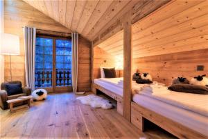 a room with two beds in a log cabin at Chalet le Petou in Champéry +8 photos