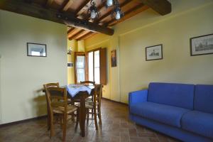 un soggiorno con divano blu e tavolo di Casa Mire, San Gimignano a Gambassi