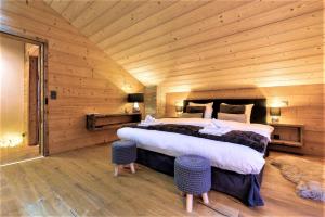 sypialnia z dużym łóżkiem w drewnianym pokoju w obiekcie Chalet le Petou w mieście Champéry