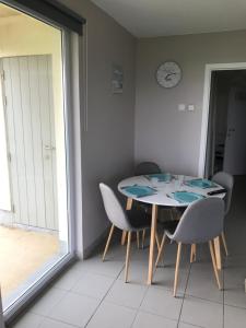 een eetkamer met een tafel en stoelen en een raam bij Appartement dans Résidence les Dunes du Golf in Wimereux +9 foto's